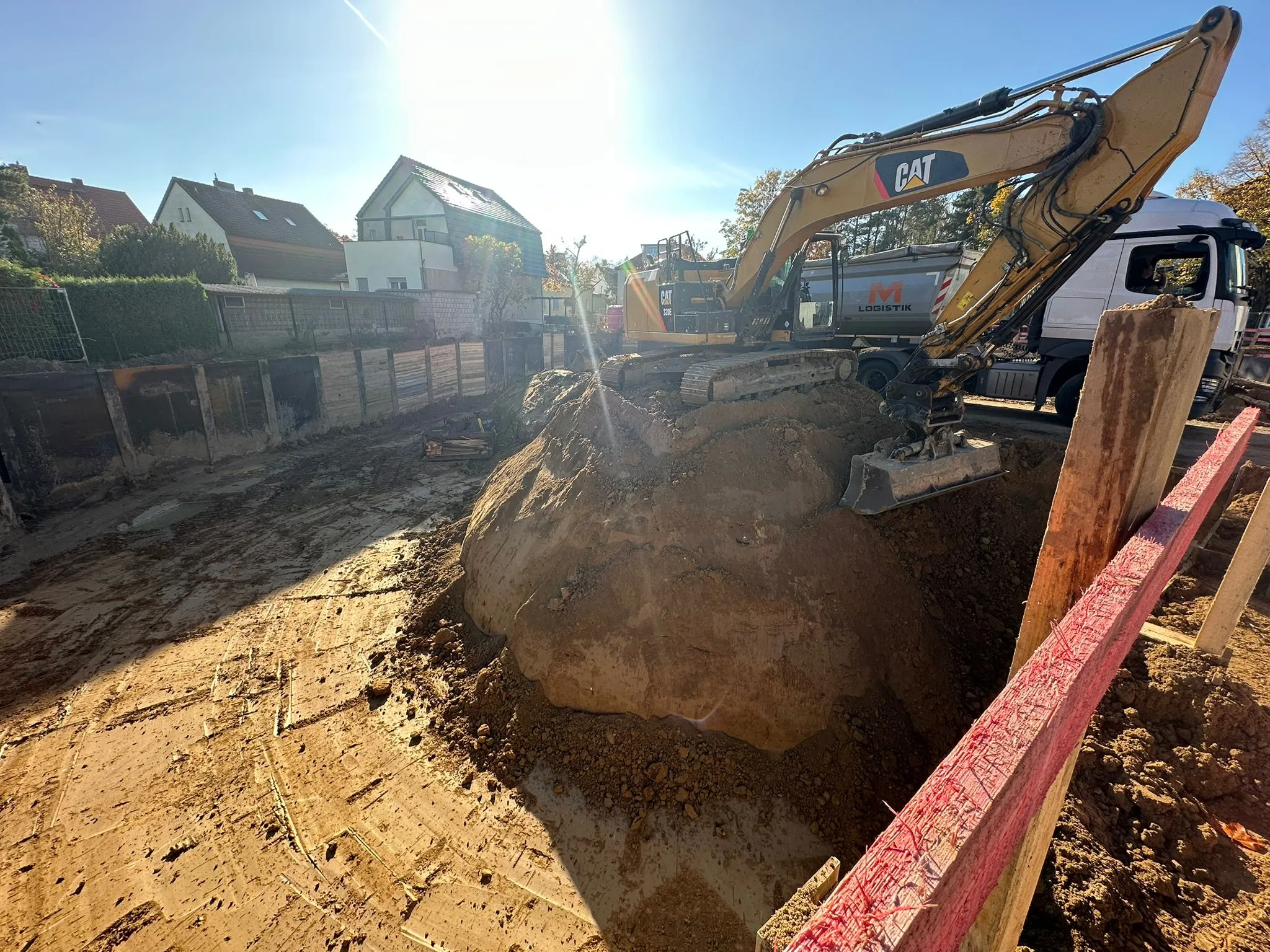Auszubildender im Baumaschinen-Umfeld: CAT-Kettenbagger im Aushub einer Baugrube auf einer Cavator-Baustelle in Berlin