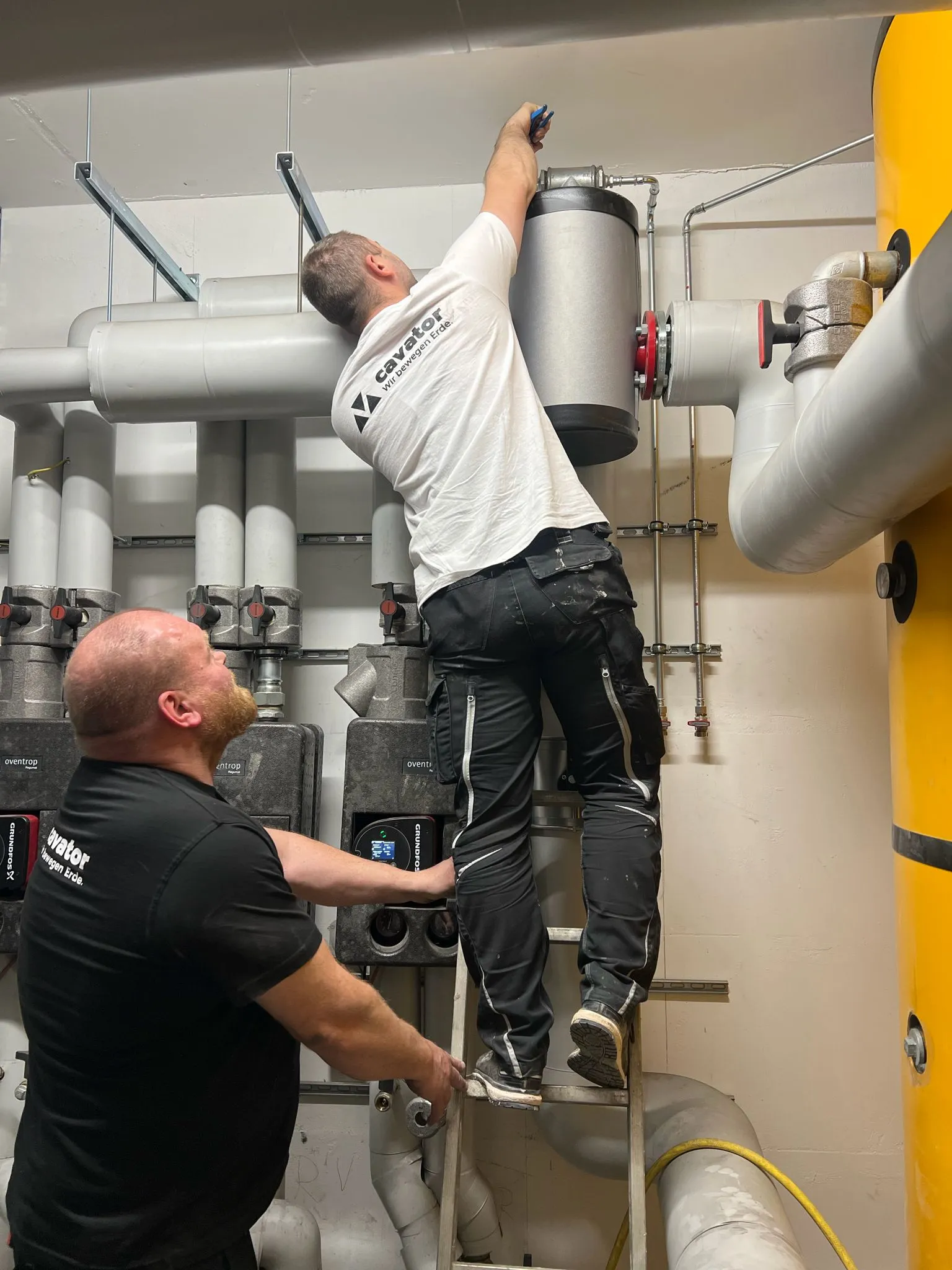 Cavator-Team bei der Wartung und Inbetriebnahme einer Hausstation mit Wärmetauscher