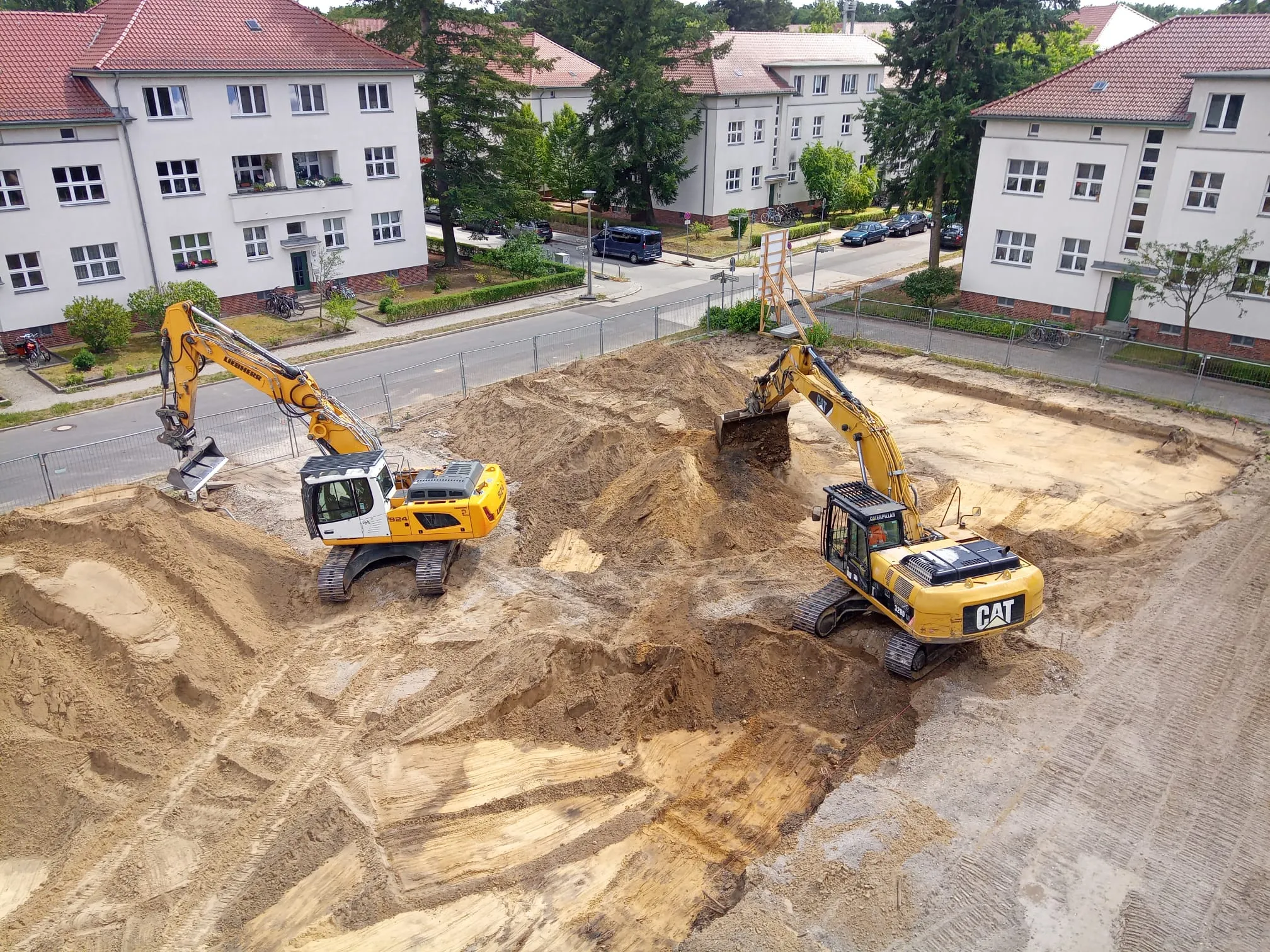 Cavator-Baustelle in Berlin: Liebherr-Bagger und CAT-Kettenbagger beim Aushub einer Baugrube in einem Wohnquartier